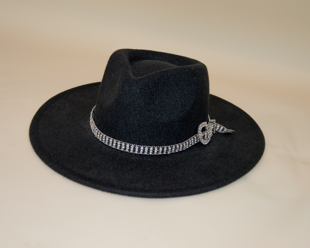 Black hat with a decorative band on a beige background