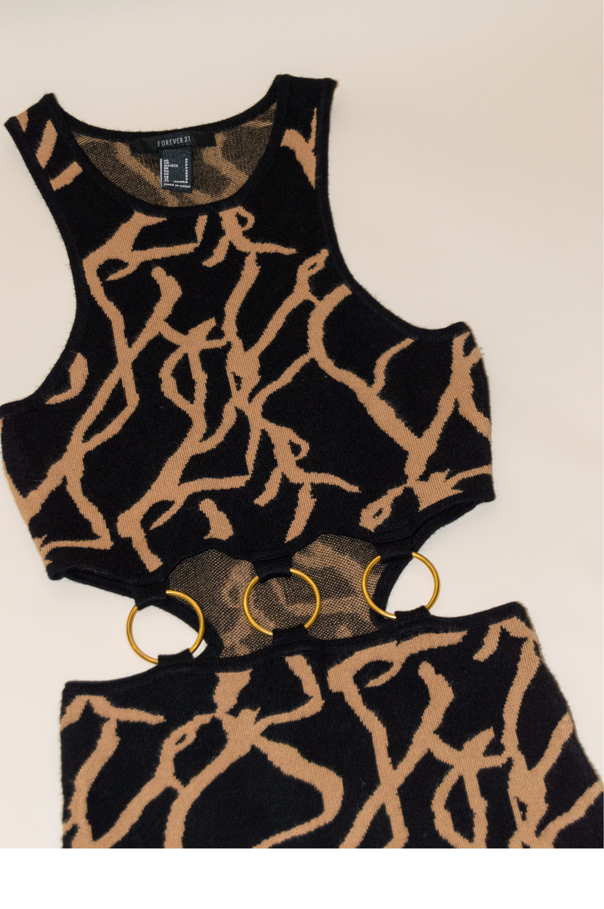 Black and gold patterned top with matching shorts on a beige background