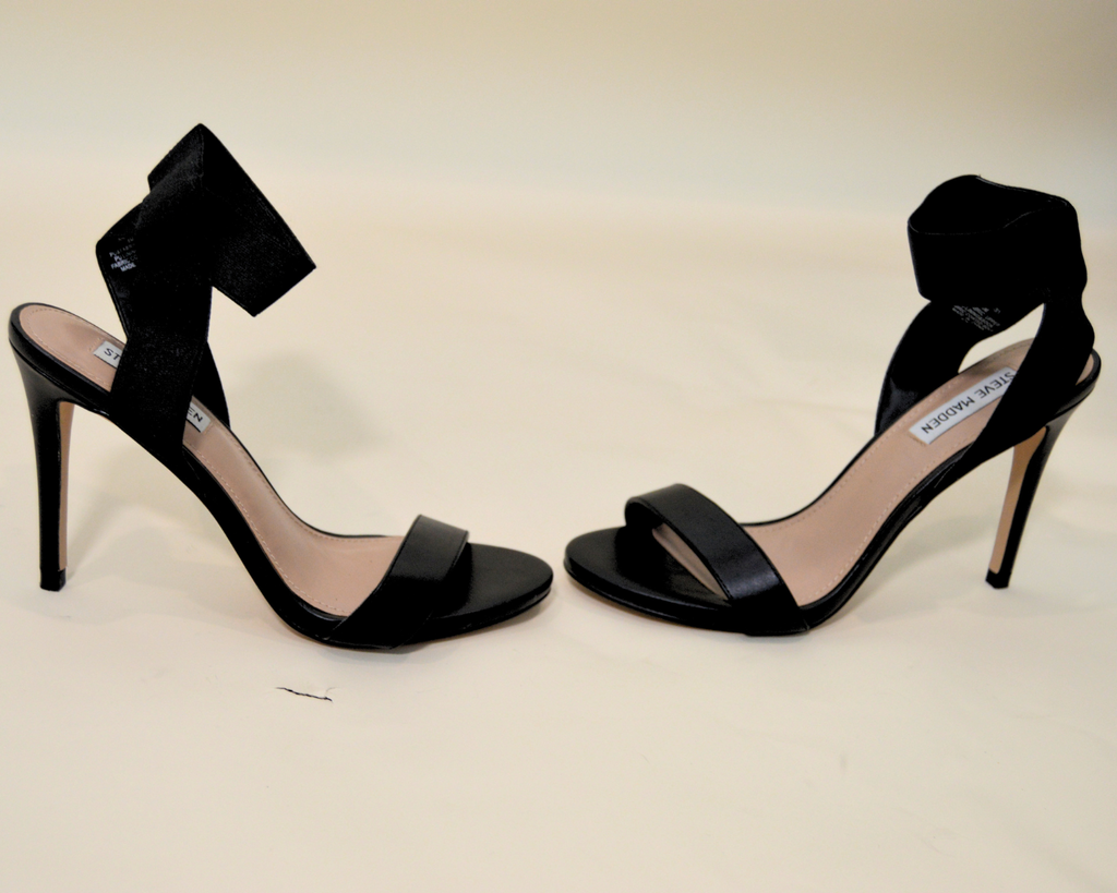 Black high-heeled shoes on a beige background