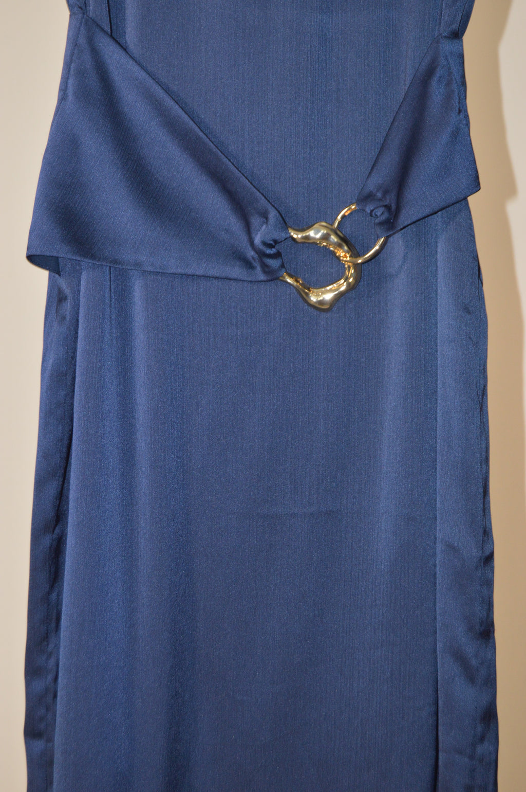 Blue fabric with a gold clasp on a beige background