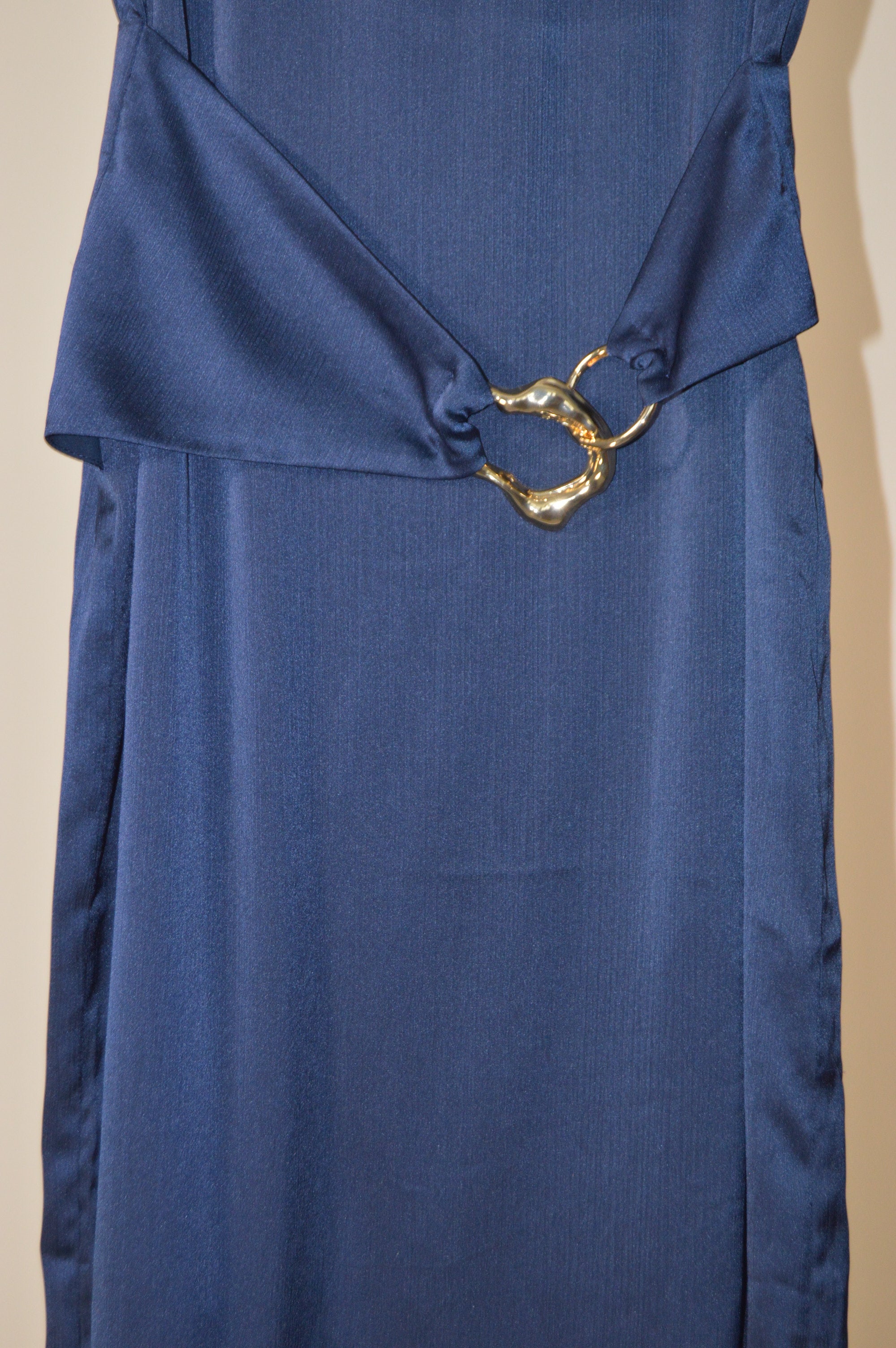 Blue fabric with a gold clasp on a beige background