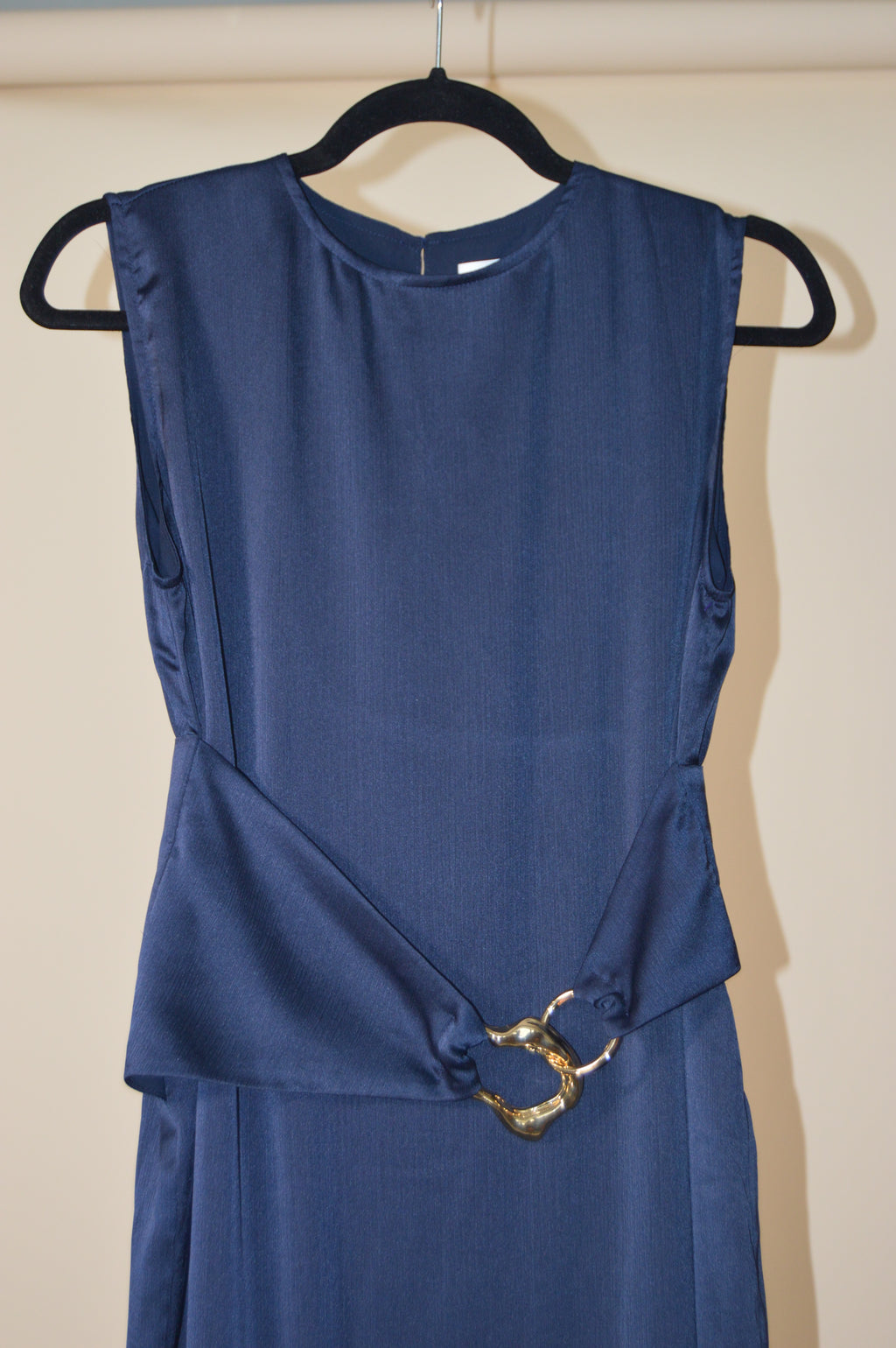 Blue dress with black straps on a beige background