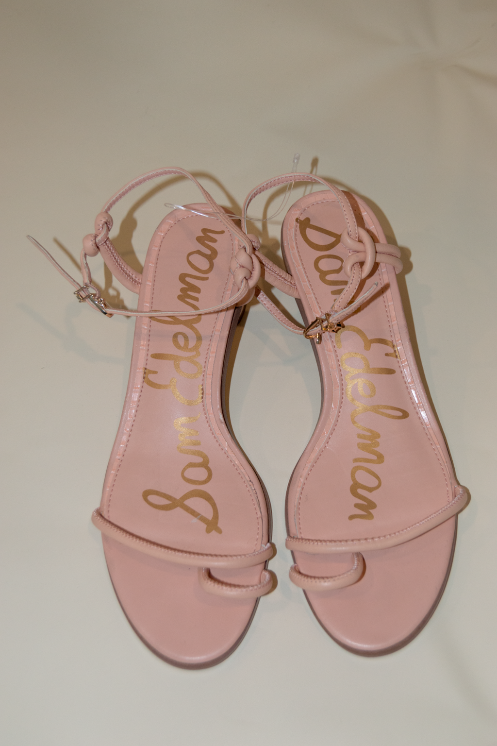 Pink sandals with 'Sam Edelman' branding on a light background