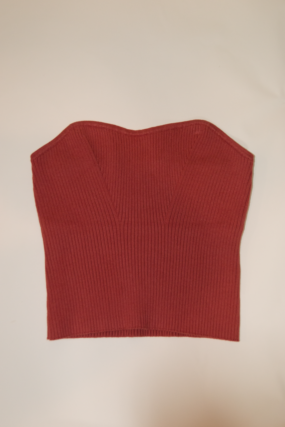 Red ribbed tank top on a beige background