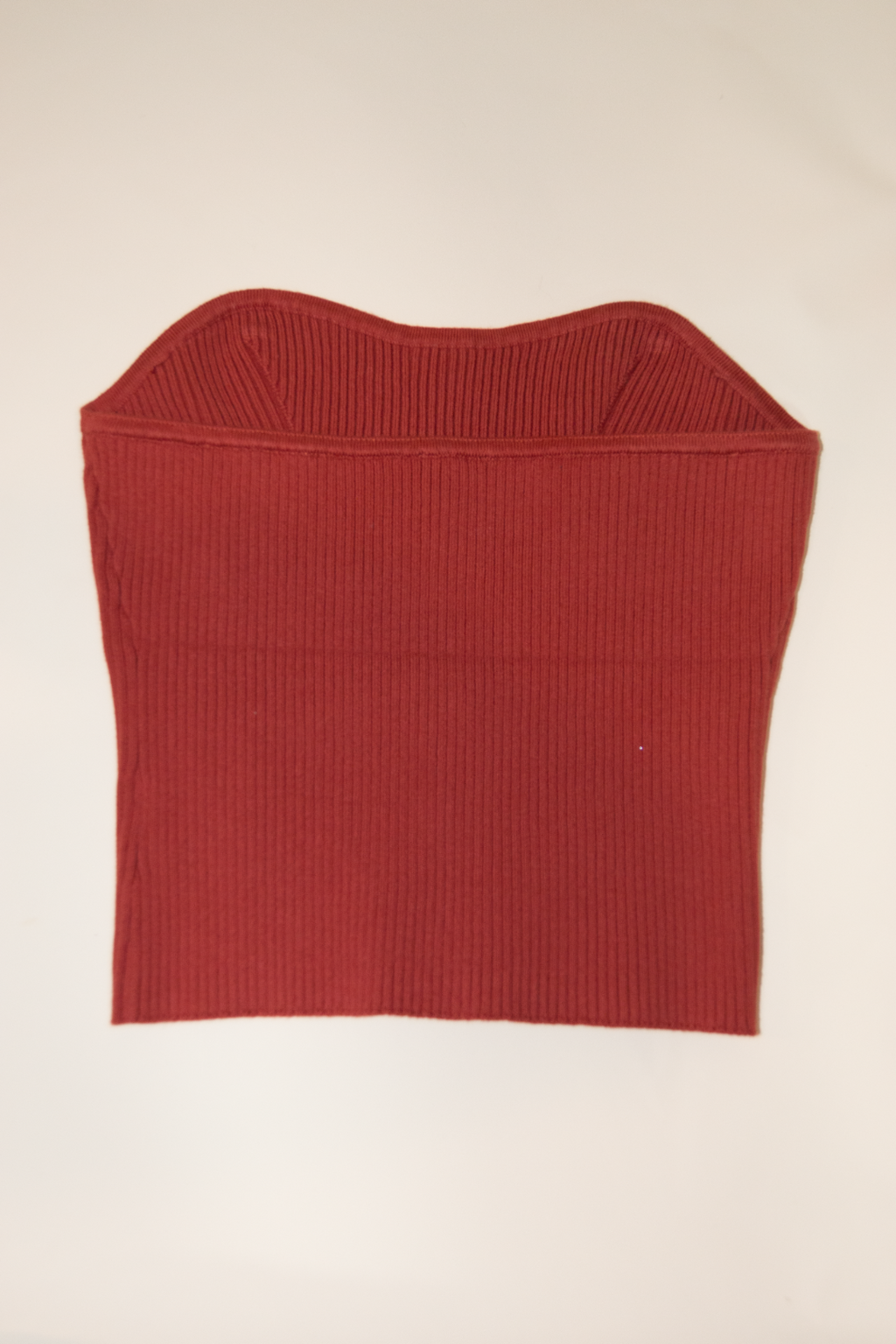 Red ribbed knit crop top on a beige background
