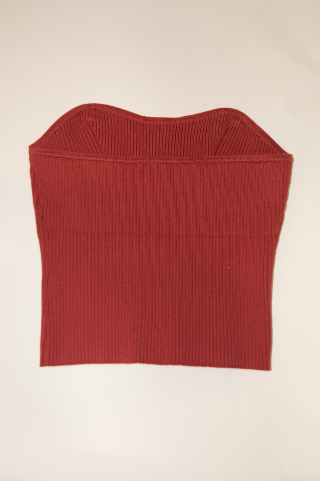 Red ribbed knit crop top on a beige background