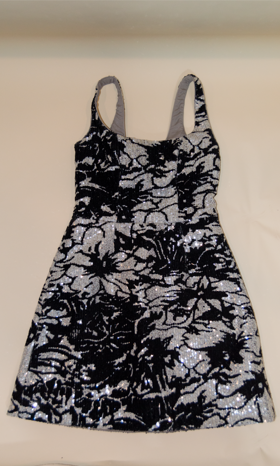 Black and silver patterned dress on a beige surface