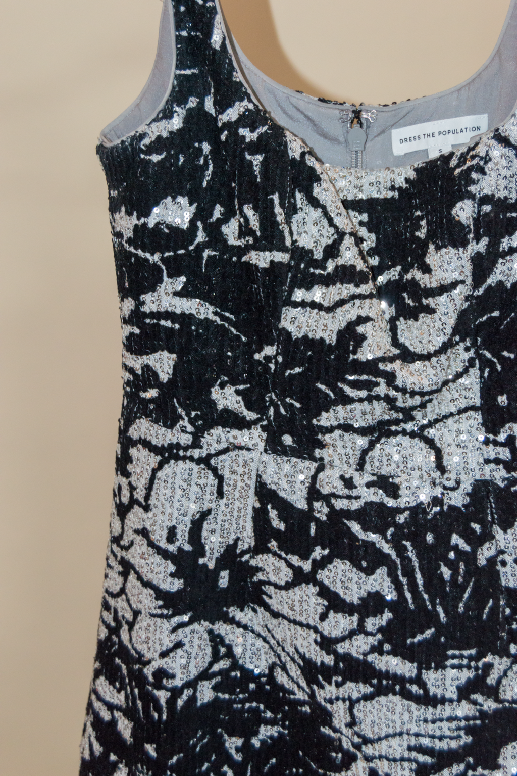 Black and silver floral patterned top on a beige background