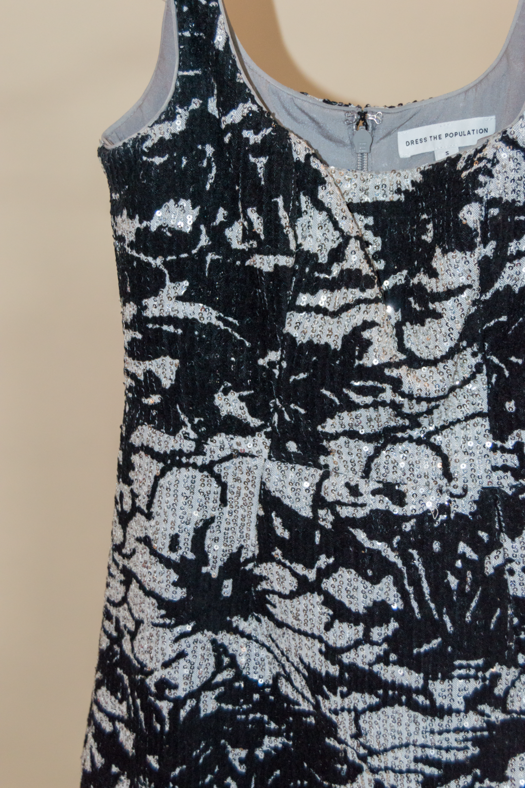 Black and silver floral patterned top on a beige background