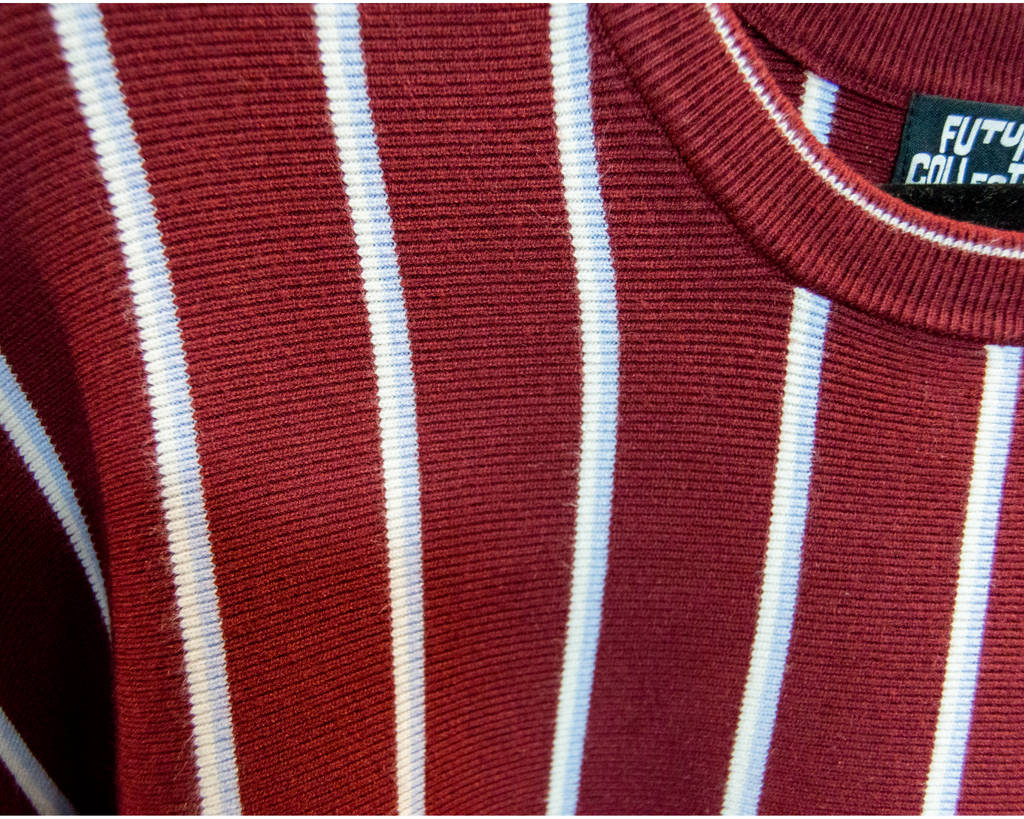 Close-up of a red and white baby blue striped garment with a brand label.