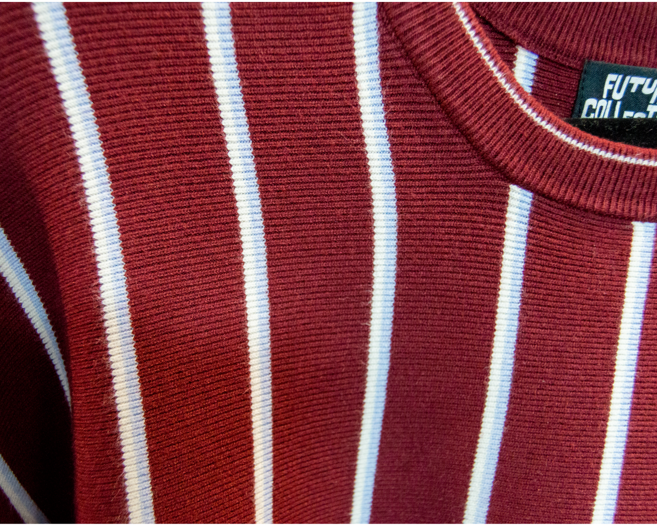 Close-up of a red and white baby blue striped garment with a brand label.