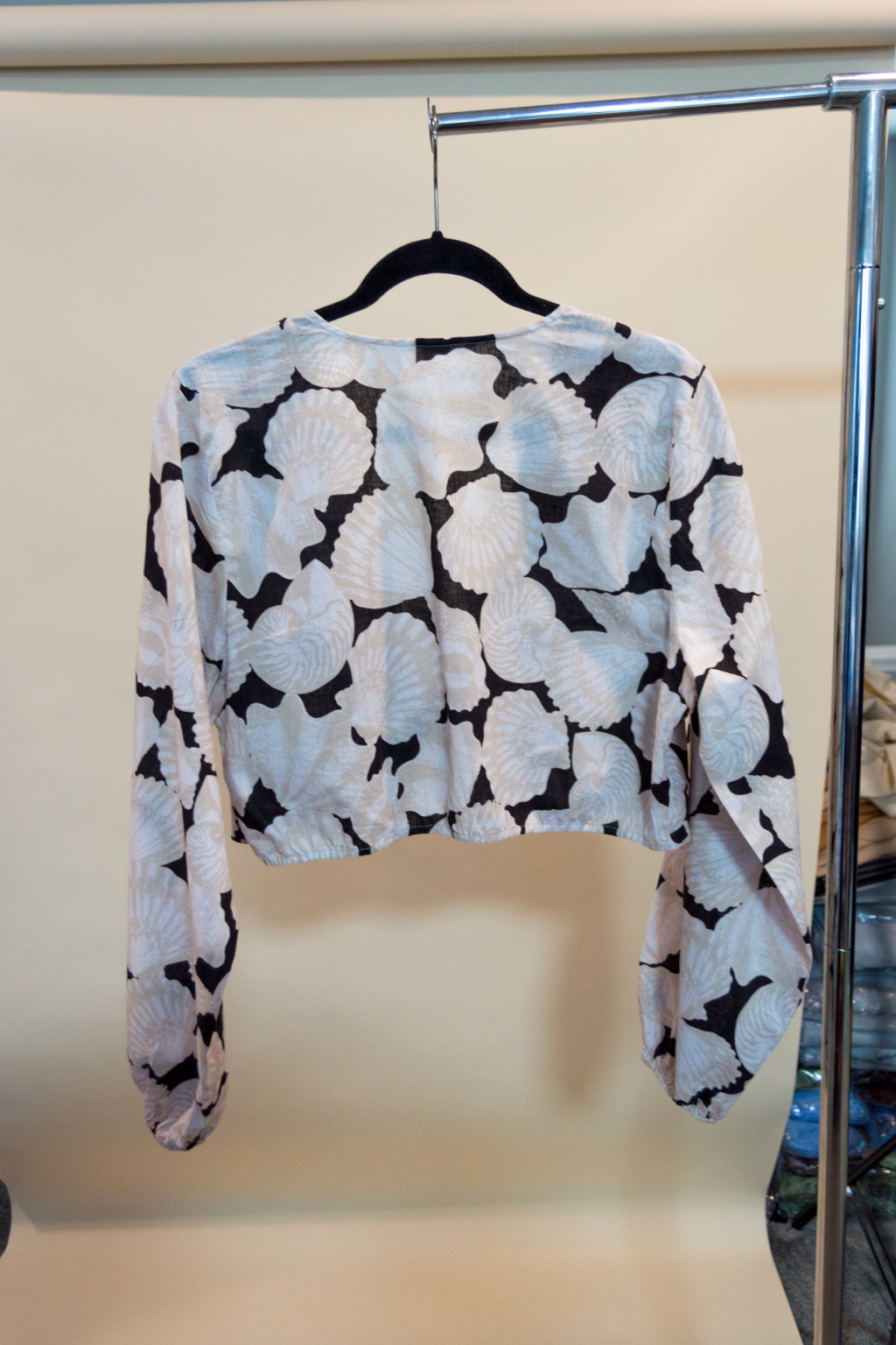Patterned top on a hanger against a plain background