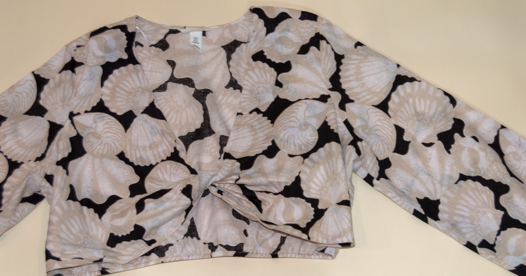 Long-sleeve top with shell pattern on a beige background